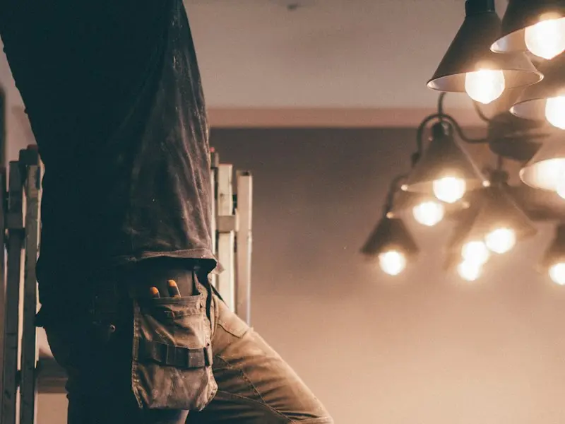 An electrician installing ceiling lights