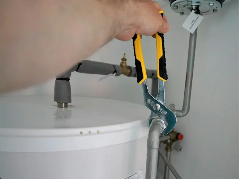 Pipework being tightened on a hot water cylinder