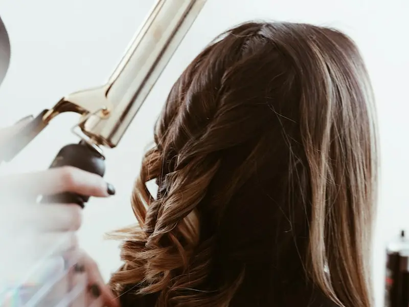 Hair being curled with a styling wand