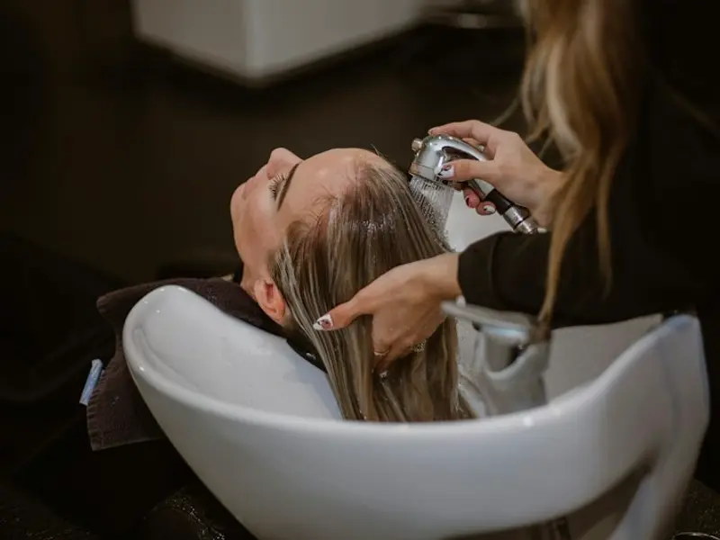 A client having their hair washed at the basin